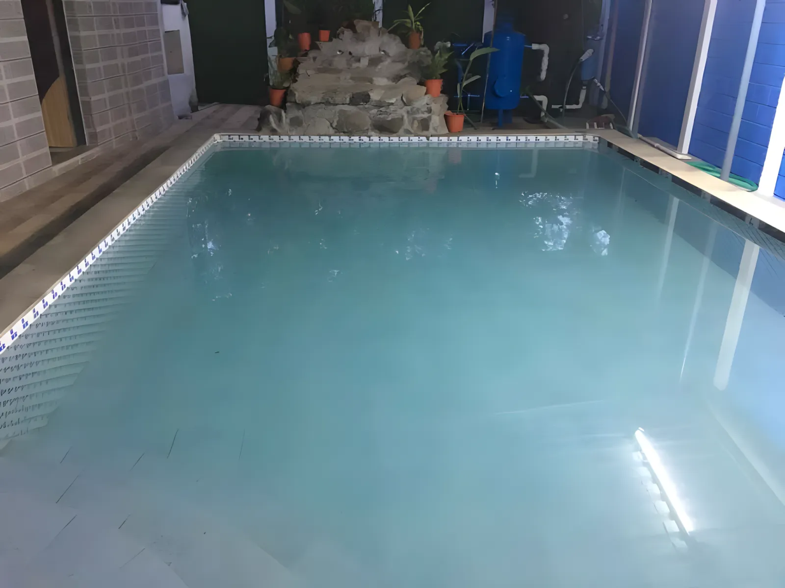 Indoor pool seating area at Dolphin House resort with swimming pool in Alibaug