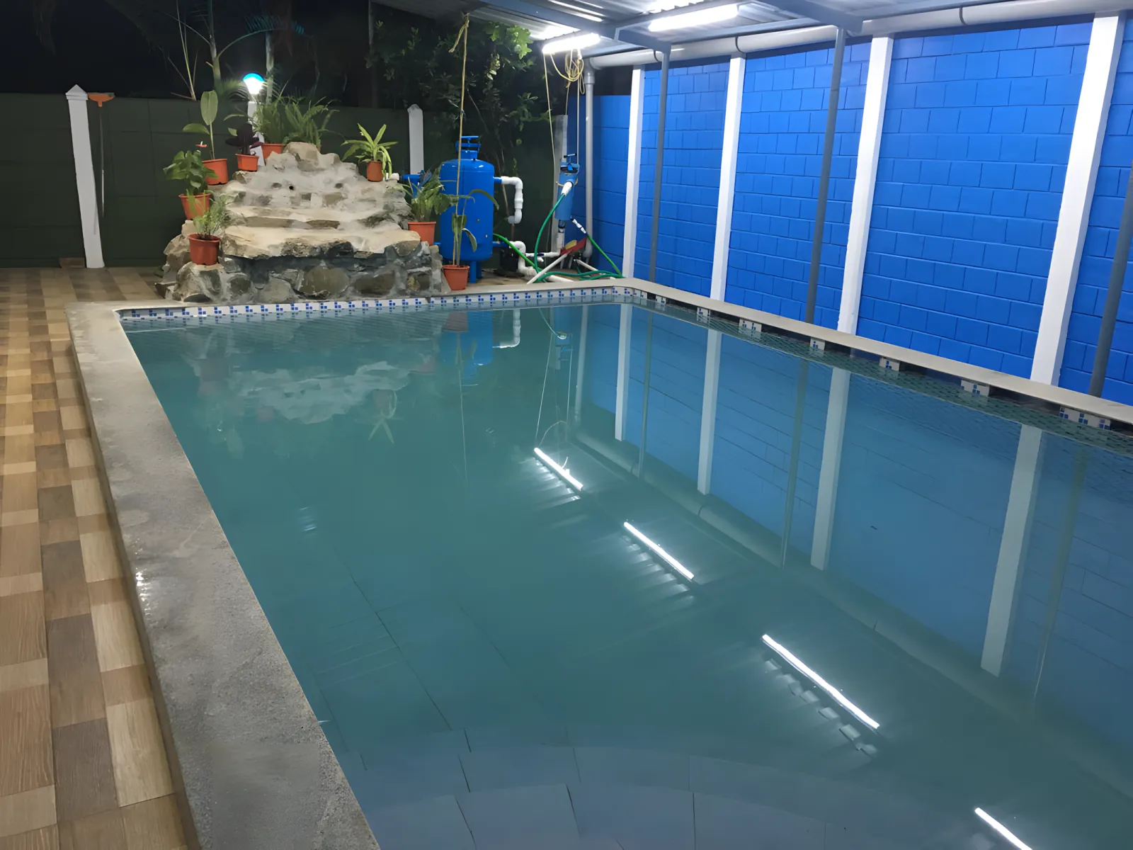 Indoor swimming pool with waterfall at Dolphin House resort in Nagaon Alibaug
